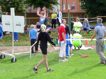 Harald Helander hoppar längd medan Anders Hansson och Martin Carlström tittar på och Benjamin tittar bort